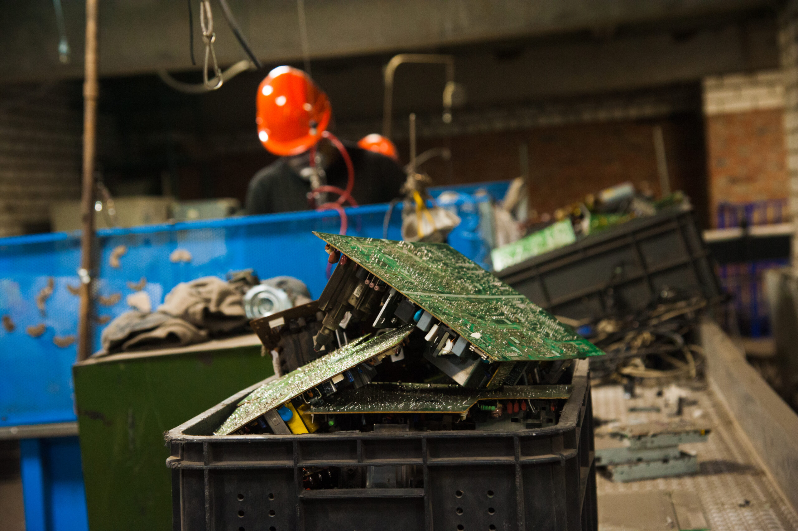 Industrial electronics recycling facility with e-waste bins and computers being sorted